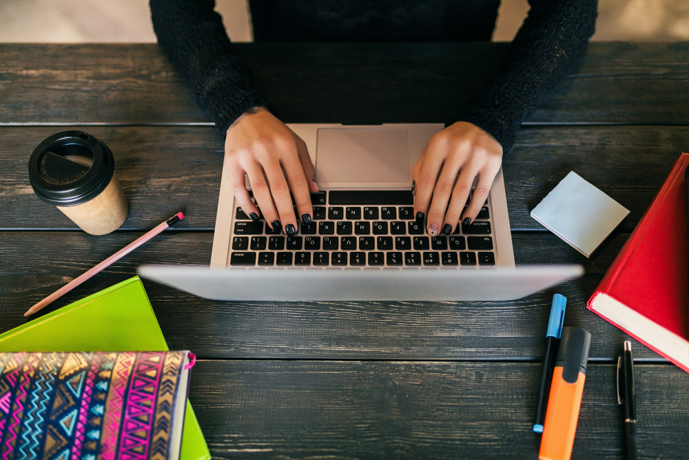 Uma mulher digitando em seu notebook criando conteúdo para agência de seo